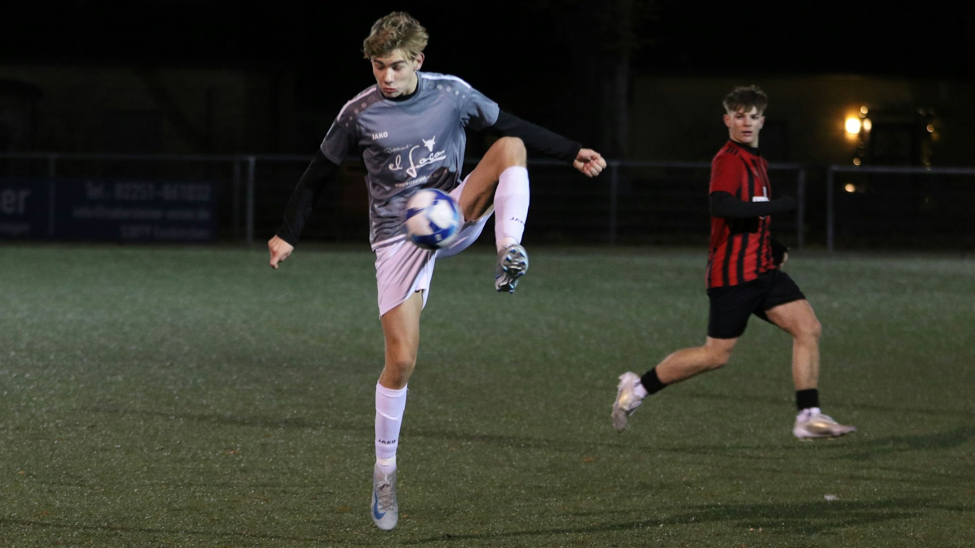 Ein Jugendfußballer stoppt den Ball auf Bauchhöhe mit einem hochgezogenen Bein.