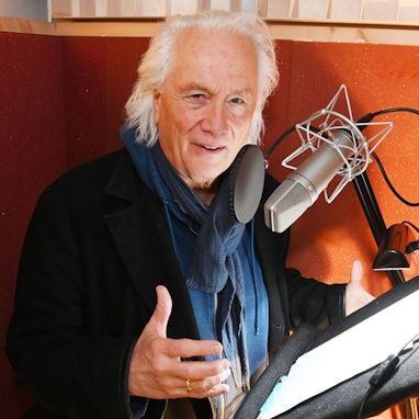 Hannes Schöner steht vorm Mikrofon im Studio.