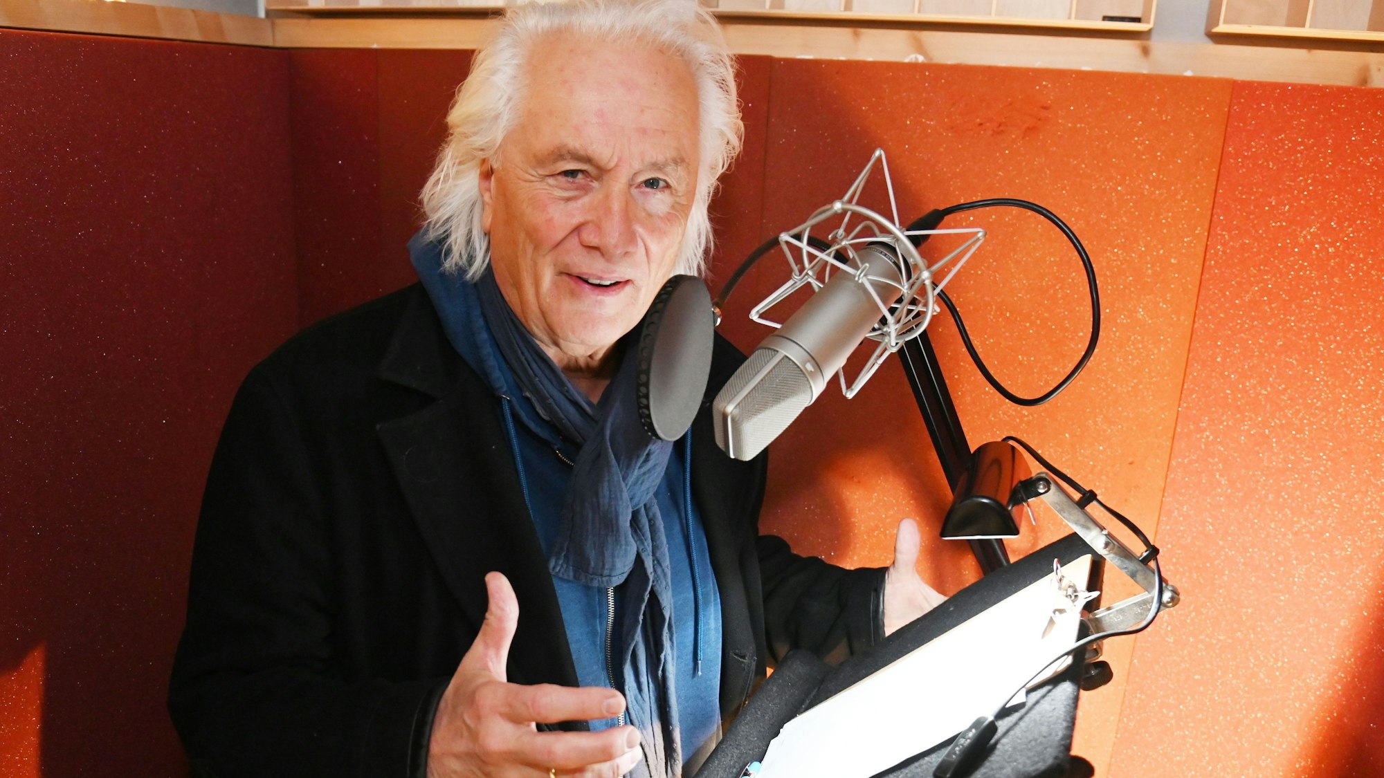 Hannes Schöner steht vorm Mikrofon im Studio.