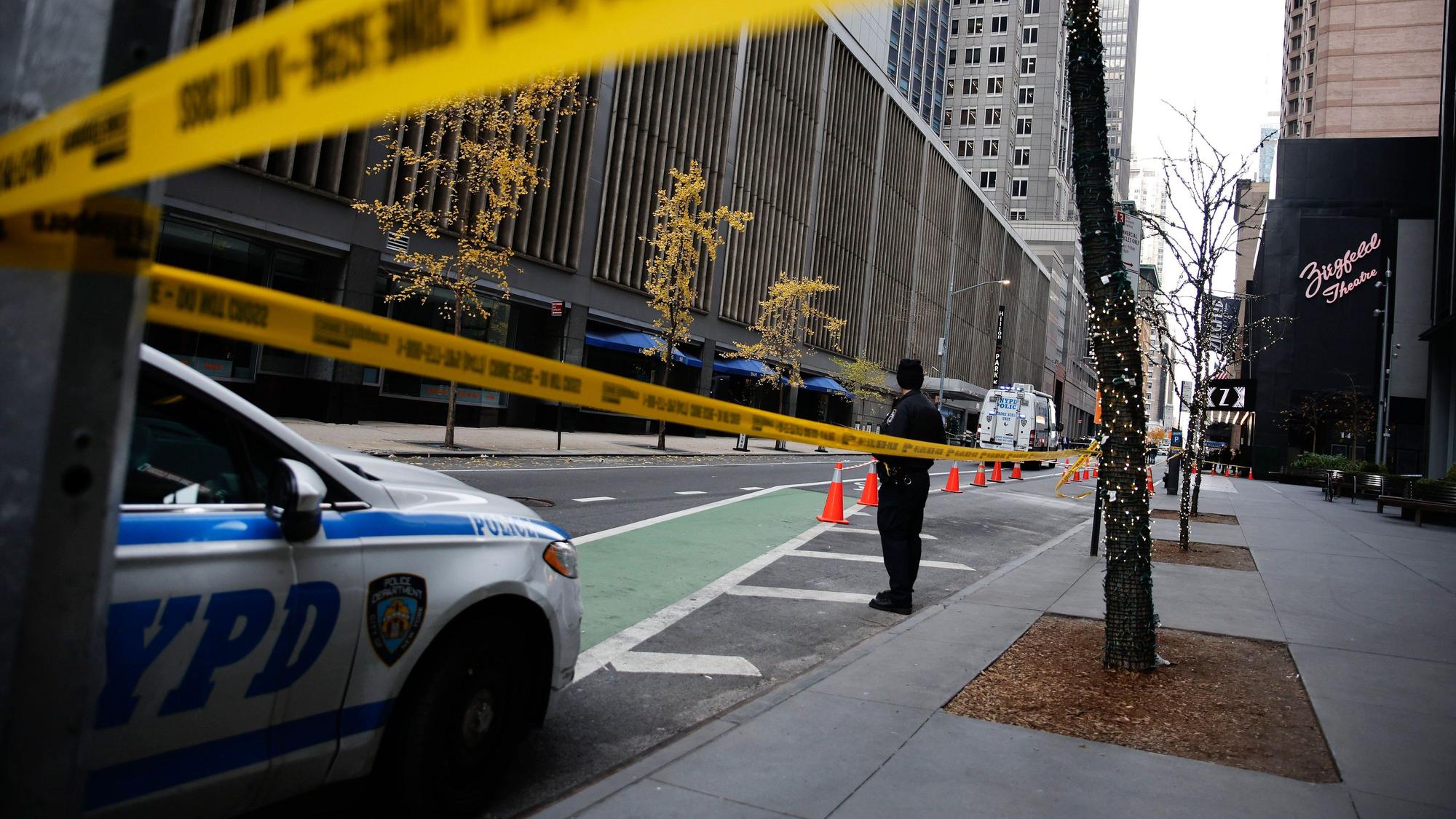 A New York police officer stands on 54th Street outside the Hilton Hotel in midtown Manhattan where Brian Thompson, the CEO of UnitedHealthcare, was fatally shot Wednesday, Dec. 4, 2024, in New York. (AP Photo/Stefan Jeremiah)