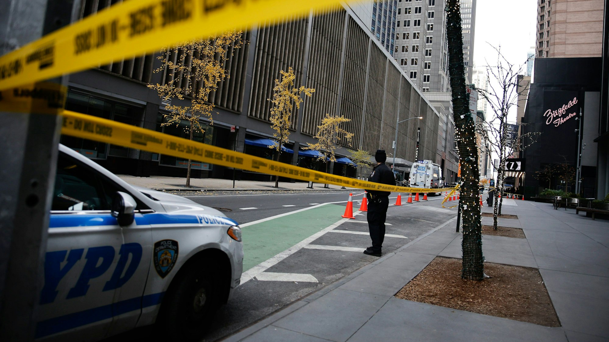 A New York police officer stands on 54th Street outside the Hilton Hotel in midtown Manhattan where Brian Thompson, the CEO of UnitedHealthcare, was fatally shot Wednesday, Dec. 4, 2024, in New York. (AP Photo/Stefan Jeremiah)