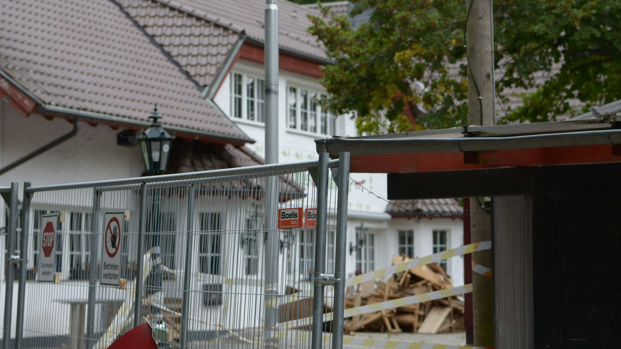 Vor dem Gasthaus liegt Sperrmüll, die Terrasse ist mit einem Bauzaun abgesperrt worden.