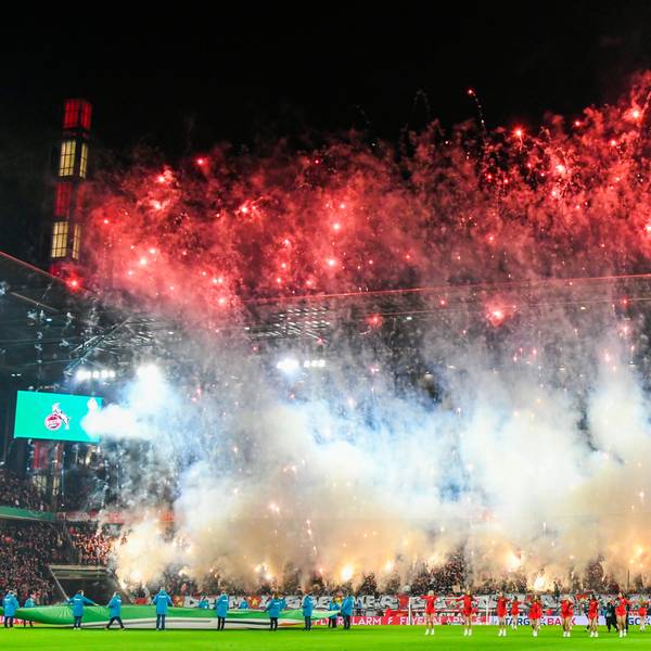 Während auf dem Rasen im Rhein-Energie-Stadion Köln Cheerleaderinnen vor der DFB-Pokal-Begegnung 1. FC Köln gegen Hertha BSC tanzen, brennen Fans große Mengen von Raketen und bengalischen Fackeln auf der Südtribüne ab.