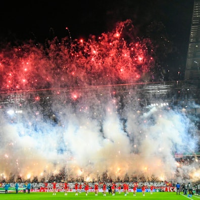 Während auf dem Rasen im Rhein-Energie-Stadion Köln Cheerleaderinnen vor der DFB-Pokal-Begegnung 1. FC Köln gegen Hertha BSC tanzen, brennen Fans große Mengen von Raketen und bengalischen Fackeln auf der Südtribüne ab.