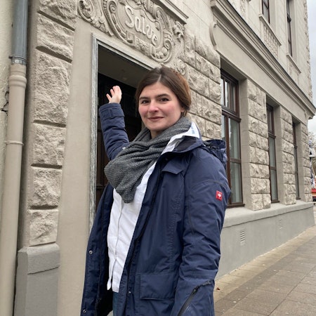 Zu sehen ist Sarah Rettig vor einer von ihr restaurierten Fassade.