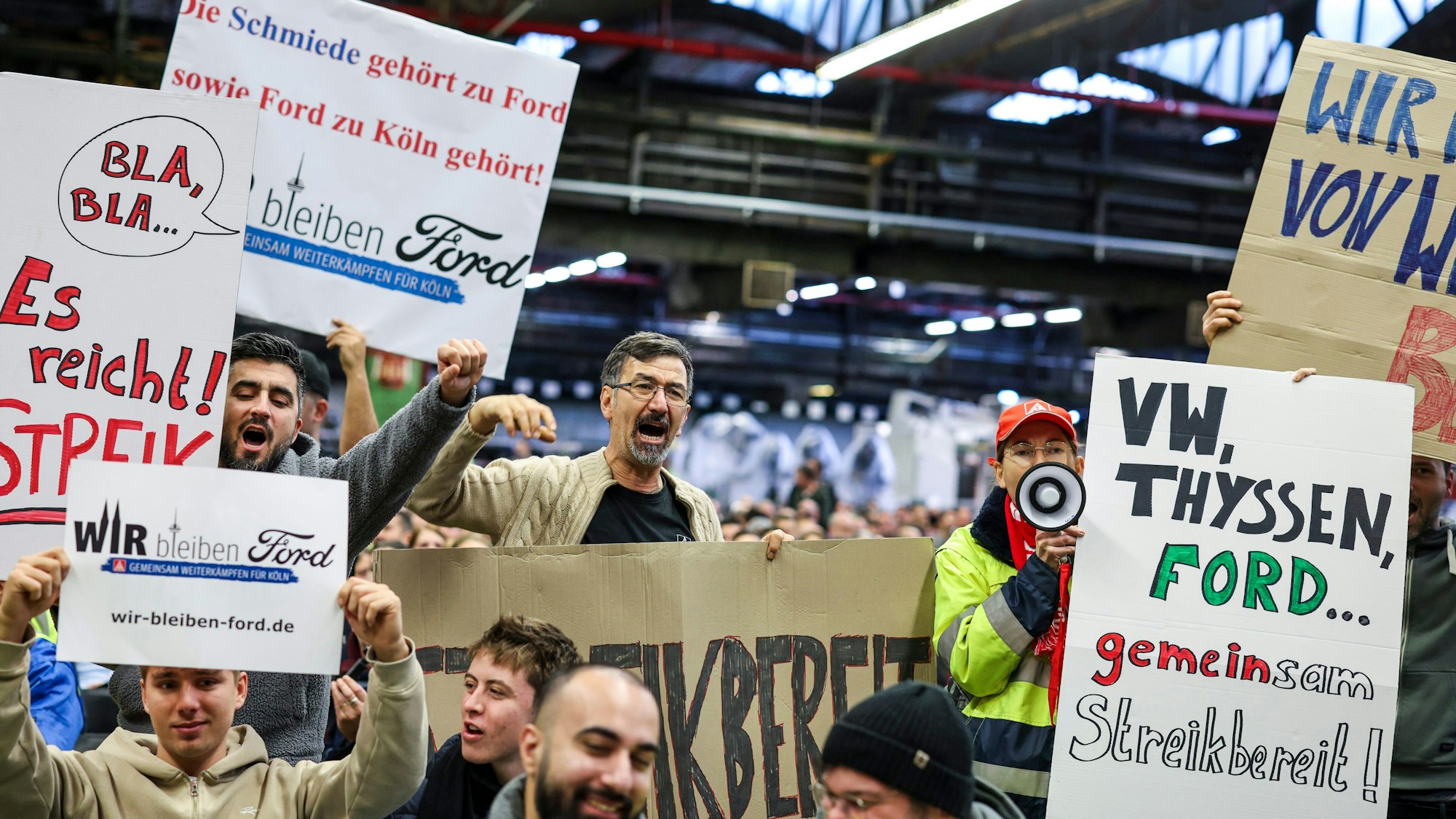 Mitarbeiter der Ford Werke in Köln demonstrieren in der Werkshalle vor der Betriebsversammlung mit Schildern wie «VW, Thyssen, Ford... gemeinsam streikbereit!».