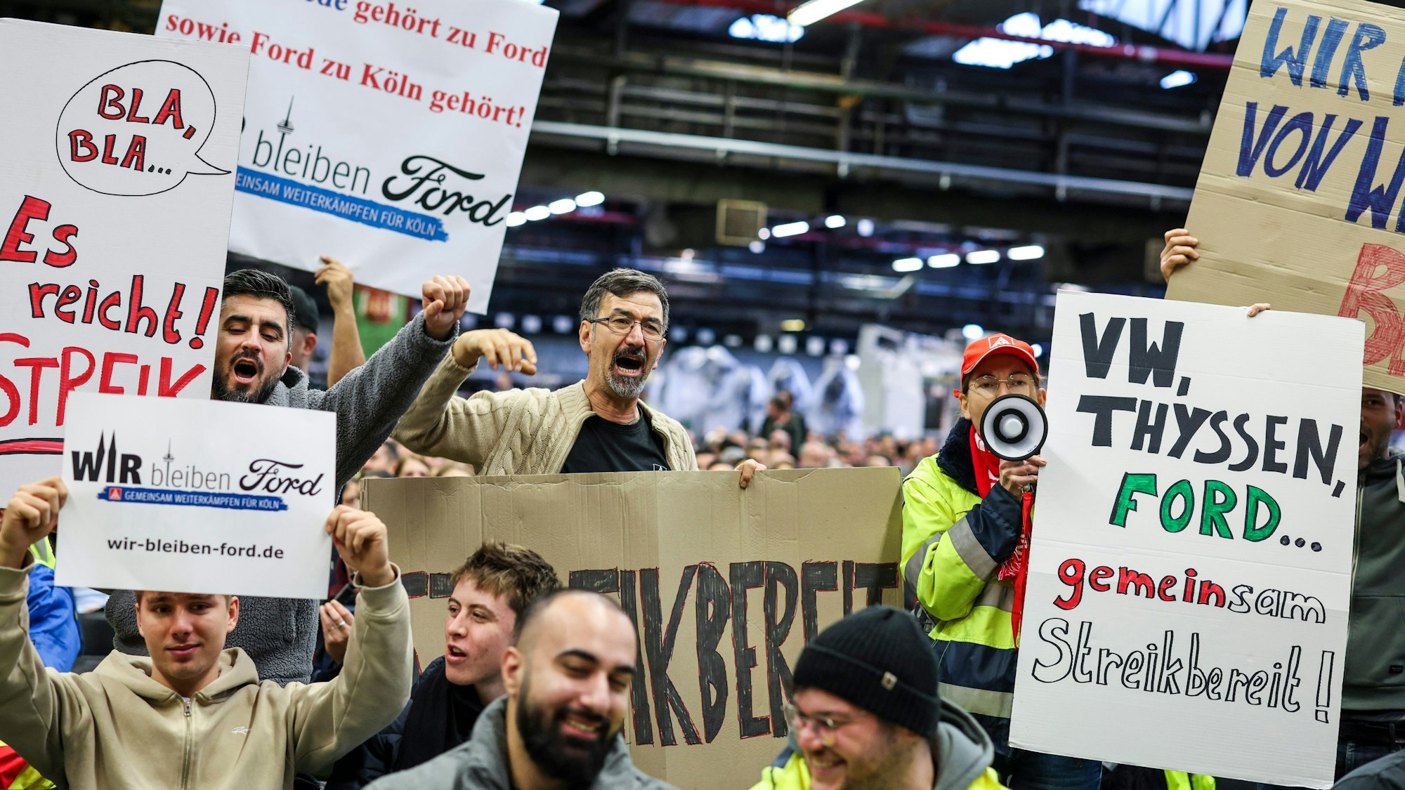 Mitarbeiter der Ford Werke in Köln demonstrieren in der Werkshalle vor der Betriebsversammlung mit Schildern wie «VW, Thyssen, Ford... gemeinsam streikbereit!».