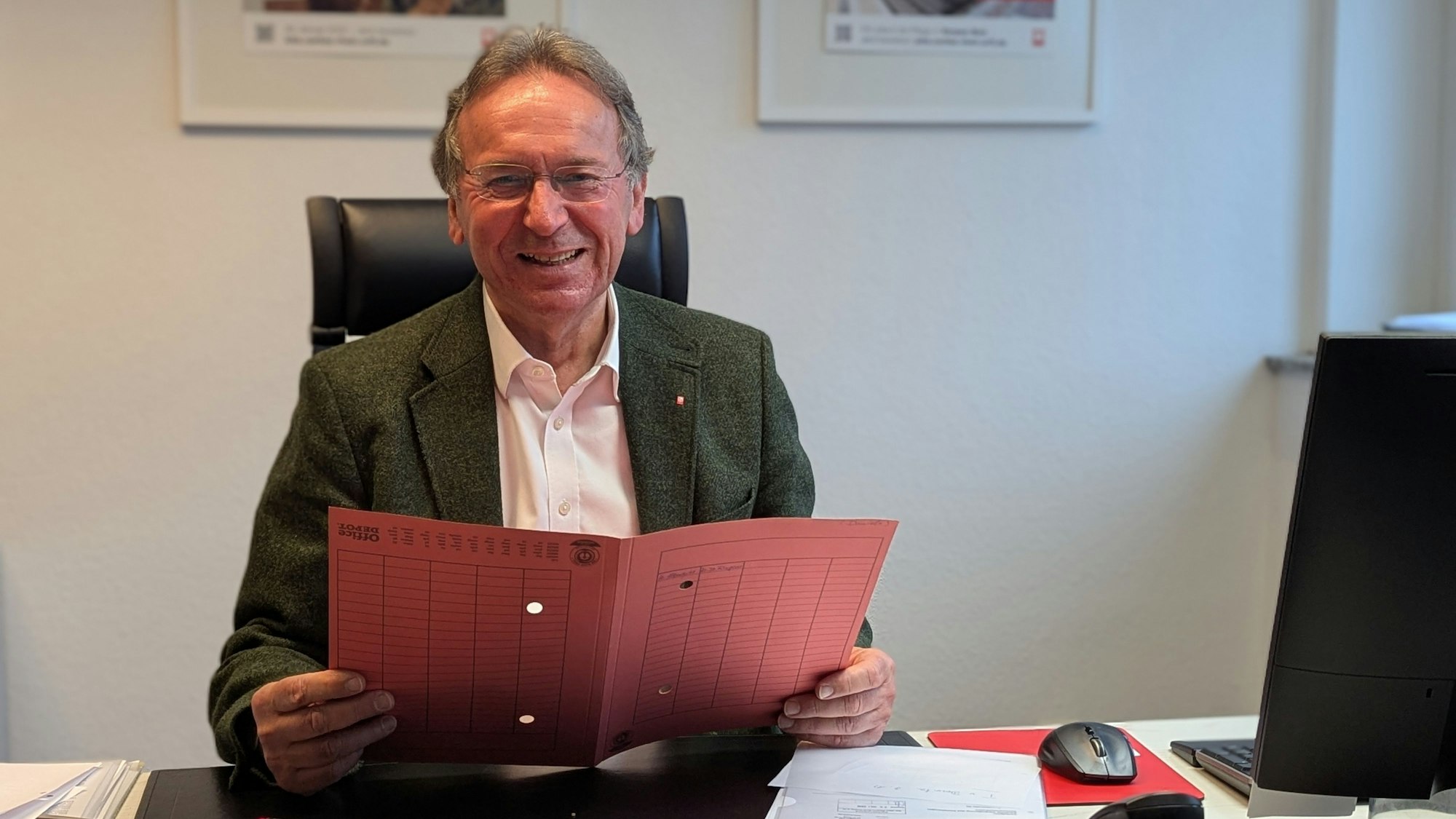 Das Foto zeigt Caritas-Vorstand Peter Altmayer mit einer Umlaufmappe an seinem Schreibtisch.