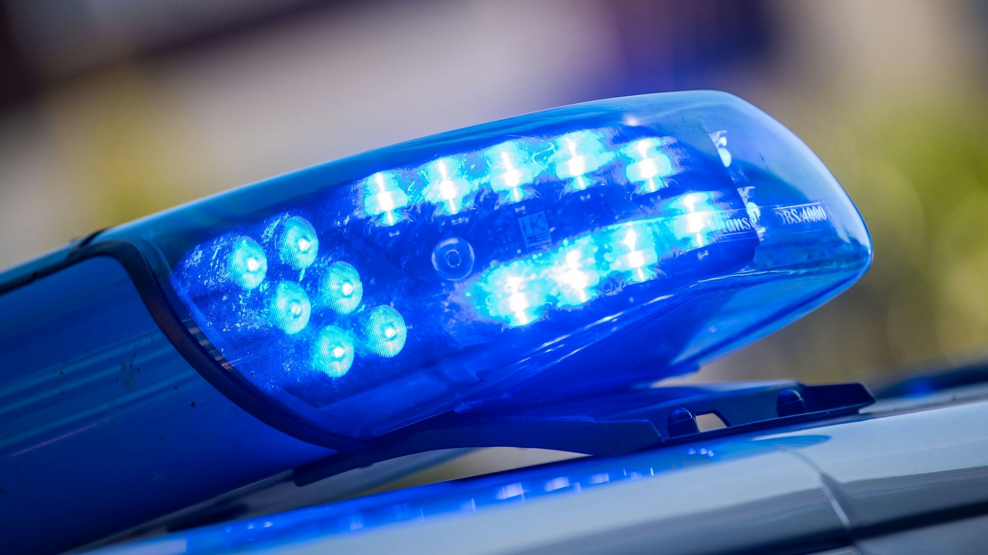 Ein Blaulicht ist auf dem Dach eines Polizeifahrzeugs zu sehen.