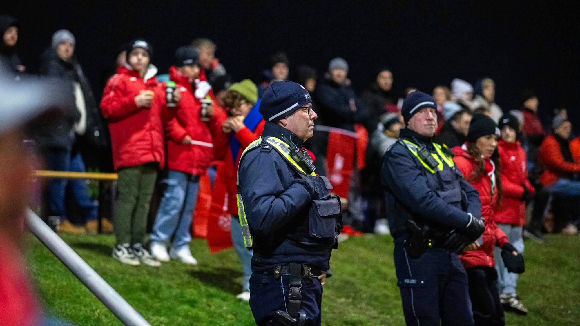 Polizisten stehen am Spielfeldrand und beobachten das Spiel.