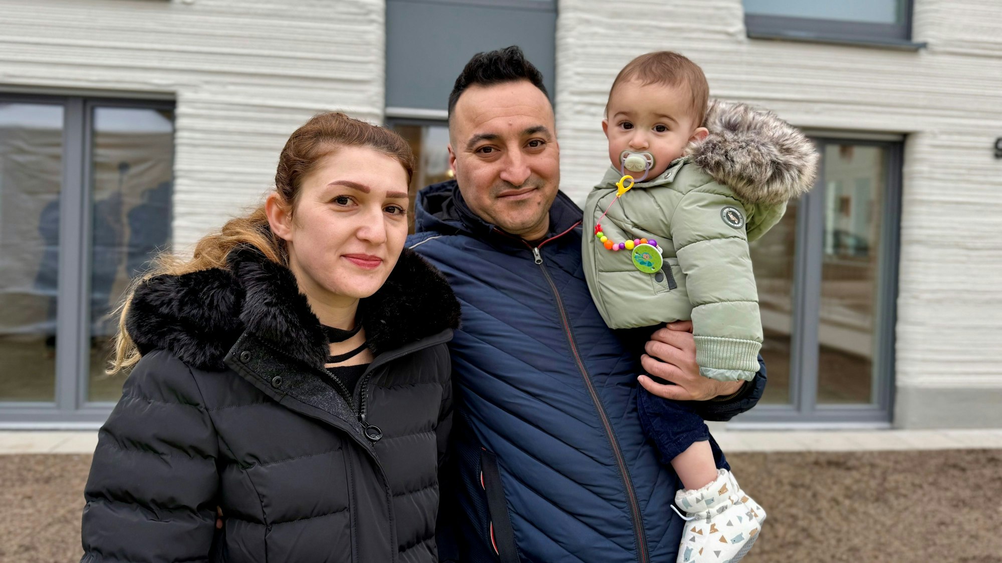 Sippan Issa, Nazdar Hassan und Sohn Saman stehen vor dem Mehrfamilienhaus