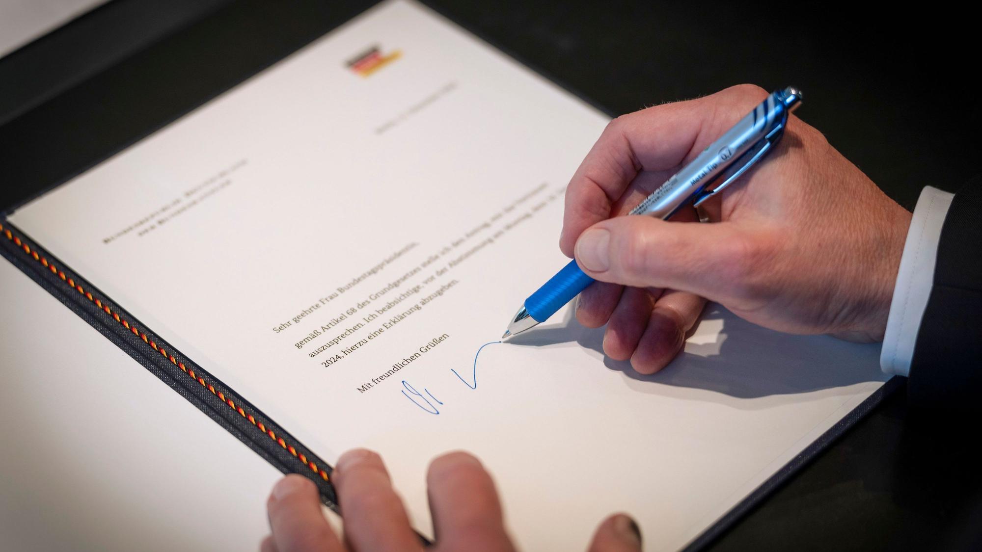 Bundeskanzler Olaf Scholz (SPD) bei der Unterzeichnung des Antrags auf Vertrauen an die Bundestagspräsidentin in seinem Büro im Bundeskanzleramt.