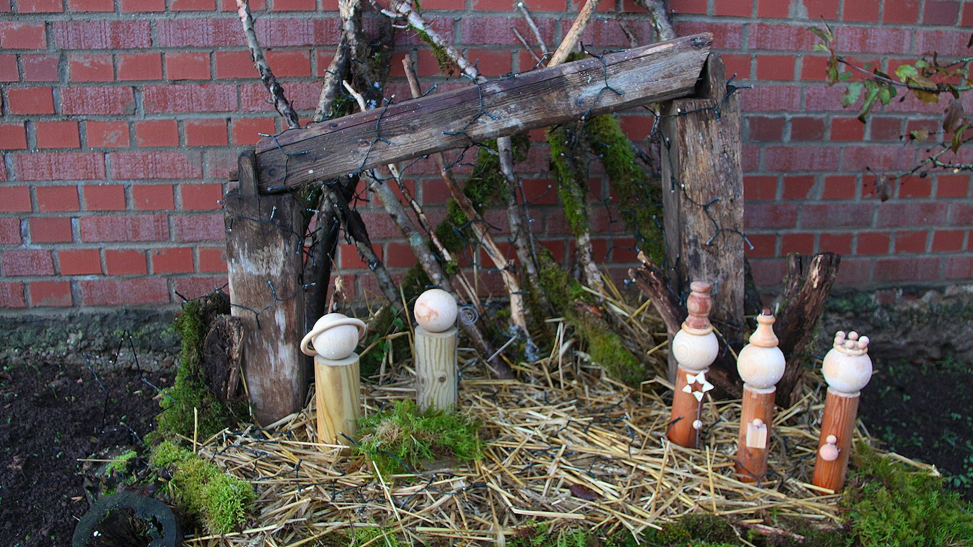 Auf Stroh stehen fünf Figuren, dahinter ein Holzgestell, das den Stall darstellt.