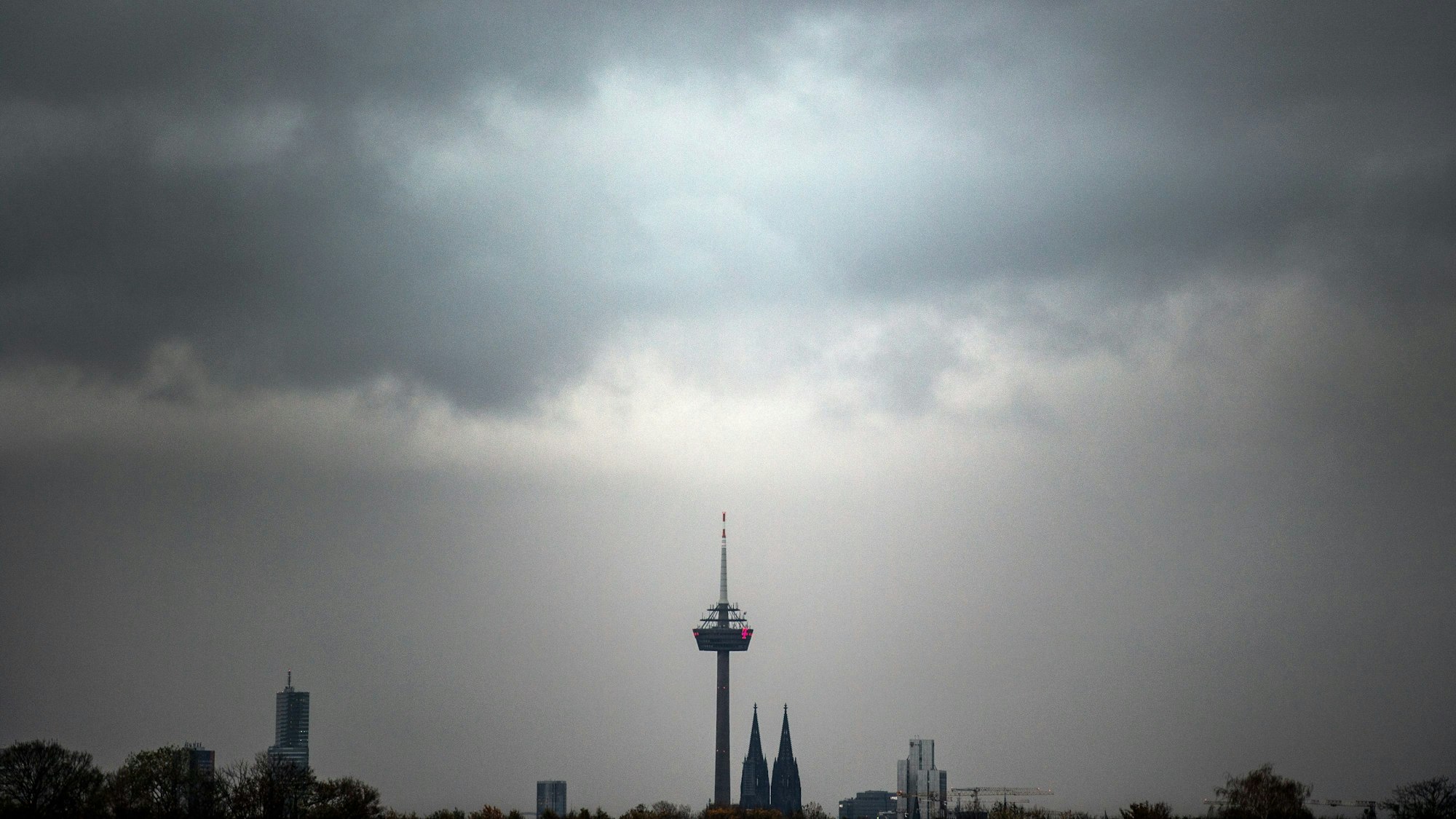 Wolken ziehen am Morgen über den Kölner Dom und den Fernsehturm.