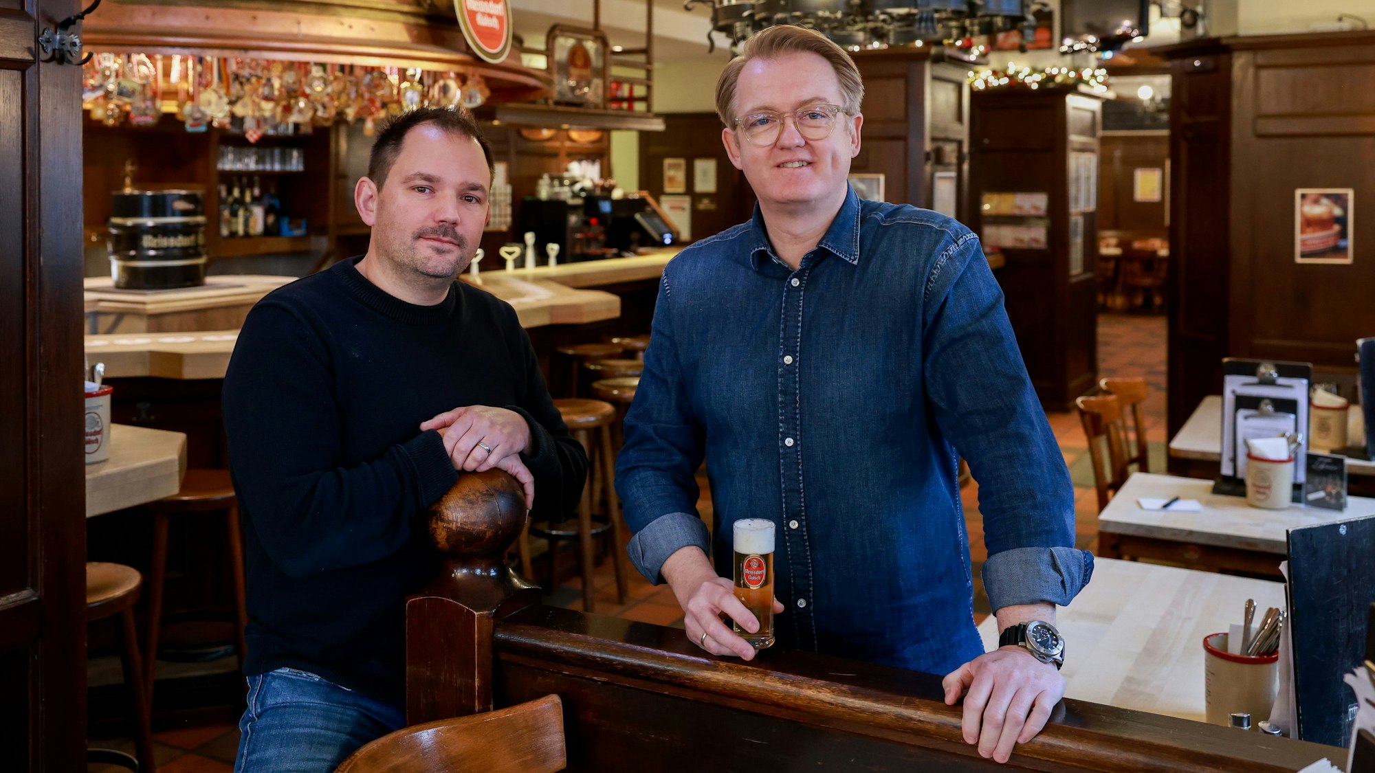 Matthias Längsfeld und Reiner Wilkens stehen im Gastraum und schauen in die Kamera