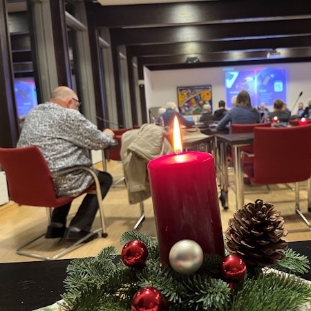 Ein Adventsgesteck mit Kerze steht im Nümbrechter Ratssaal auf einem Tisch.