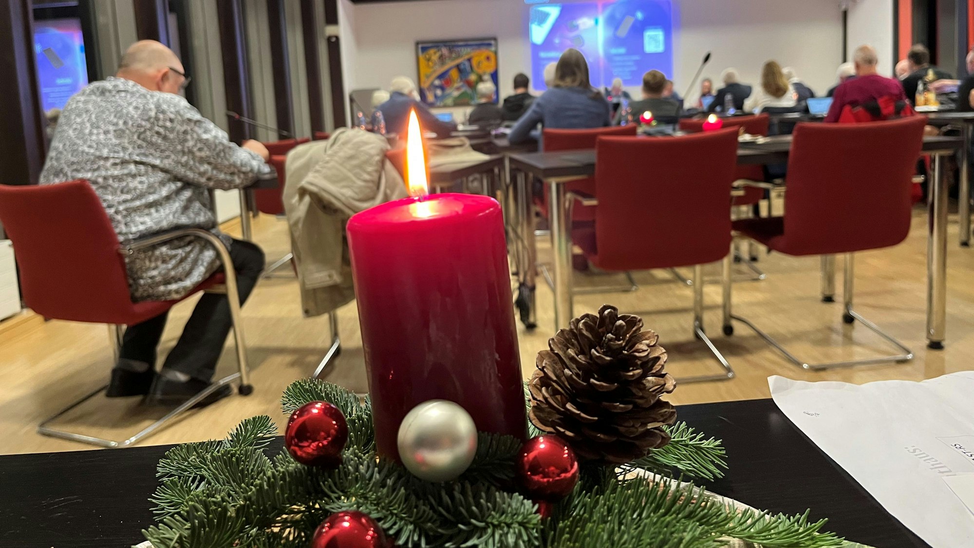 Ein Adventsgesteck mit Kerze steht im Nümbrechter Ratssaal auf einem Tisch.