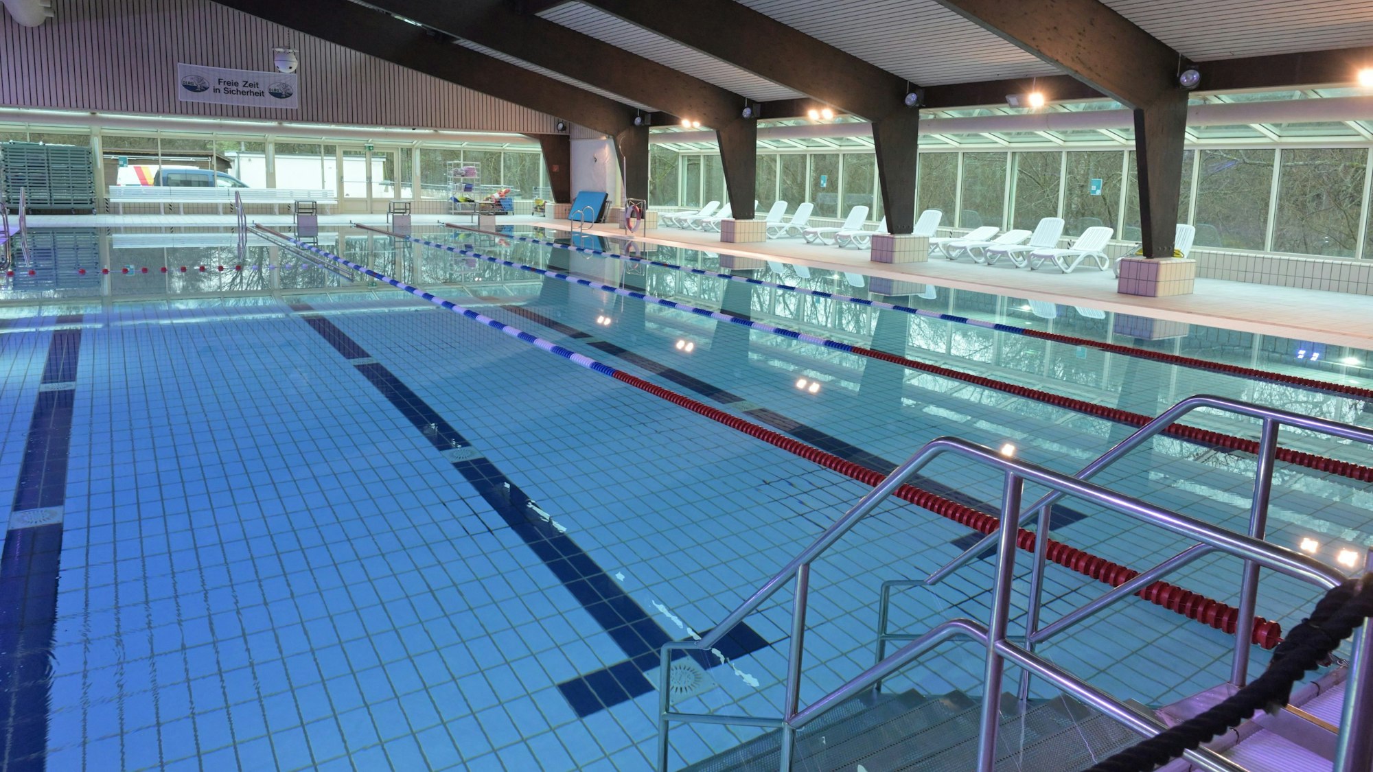 Das Schwimmbecken eines Hallenbades mit drei Bahnen und Nichtschwimmerbereich.