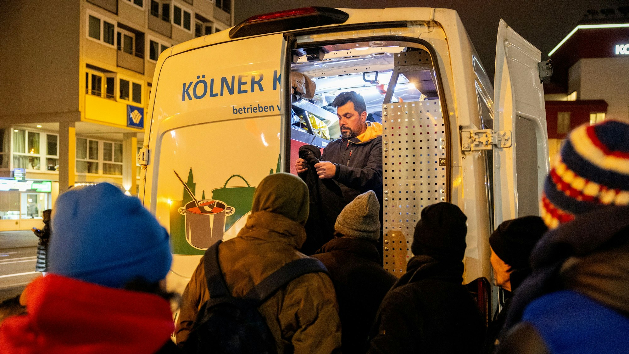 Abdolreza Mokhtari Fard vom Kältebus gibt gespendete Kleidung an Wohnungslose aus