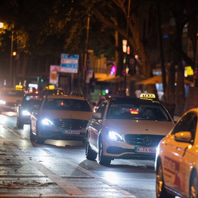 Taxis fahren im Dunkeln über den Hohenzollernring in Köln.