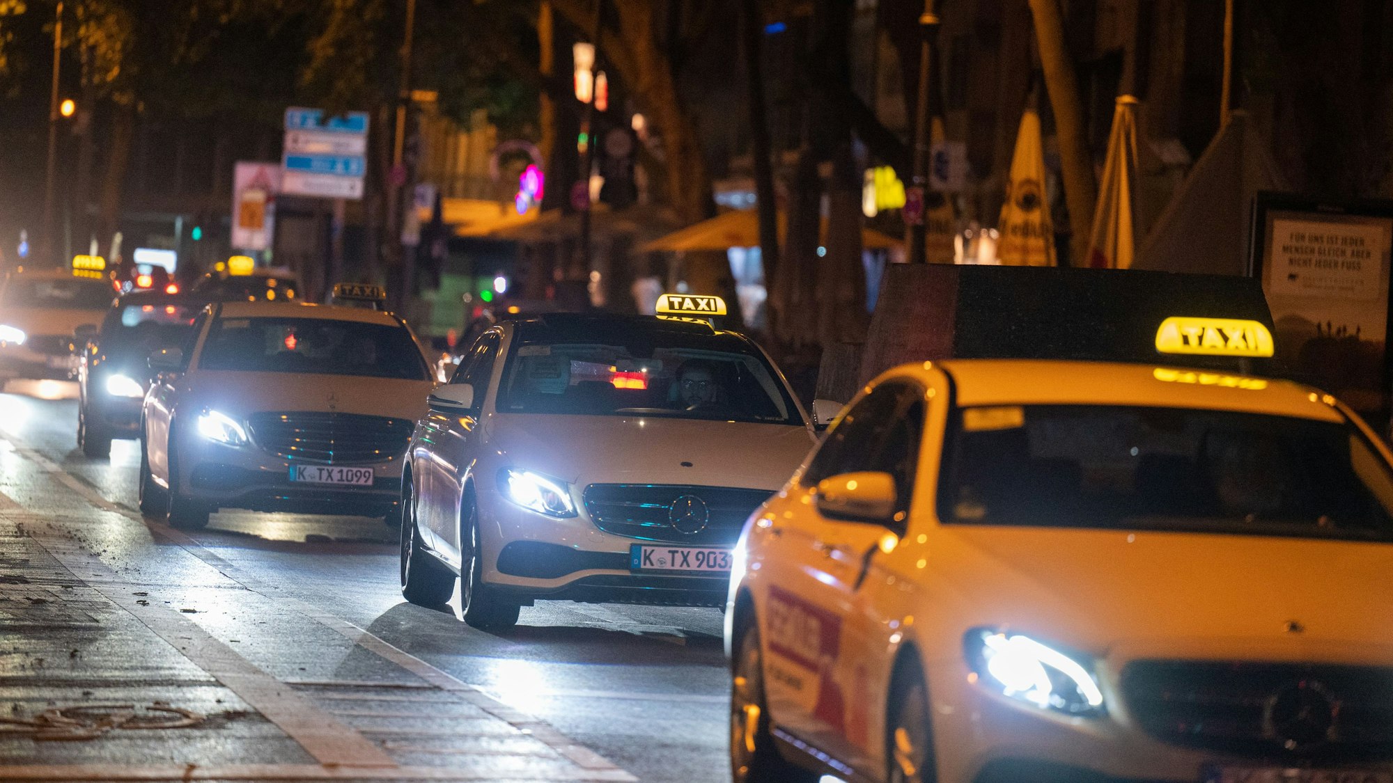 Taxis fahren im Dunkeln über den Hohenzollernring in Köln.
