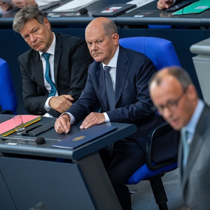 Friedrich Merz (vorn), CDU-Bundesvorsitzender und CDU/CSU Fraktionsvorsitzender im Bundestag, spricht vor Bundeskanzler Olaf Scholz (SPD, M) und Robert Habeck (Bündnis 90/Die Grünen), Bundesminister für Wirtschaft und Klimaschutz, nach der Regierungserklärung zu den Gipfeltreffen von EU und NATO im Bundestag.