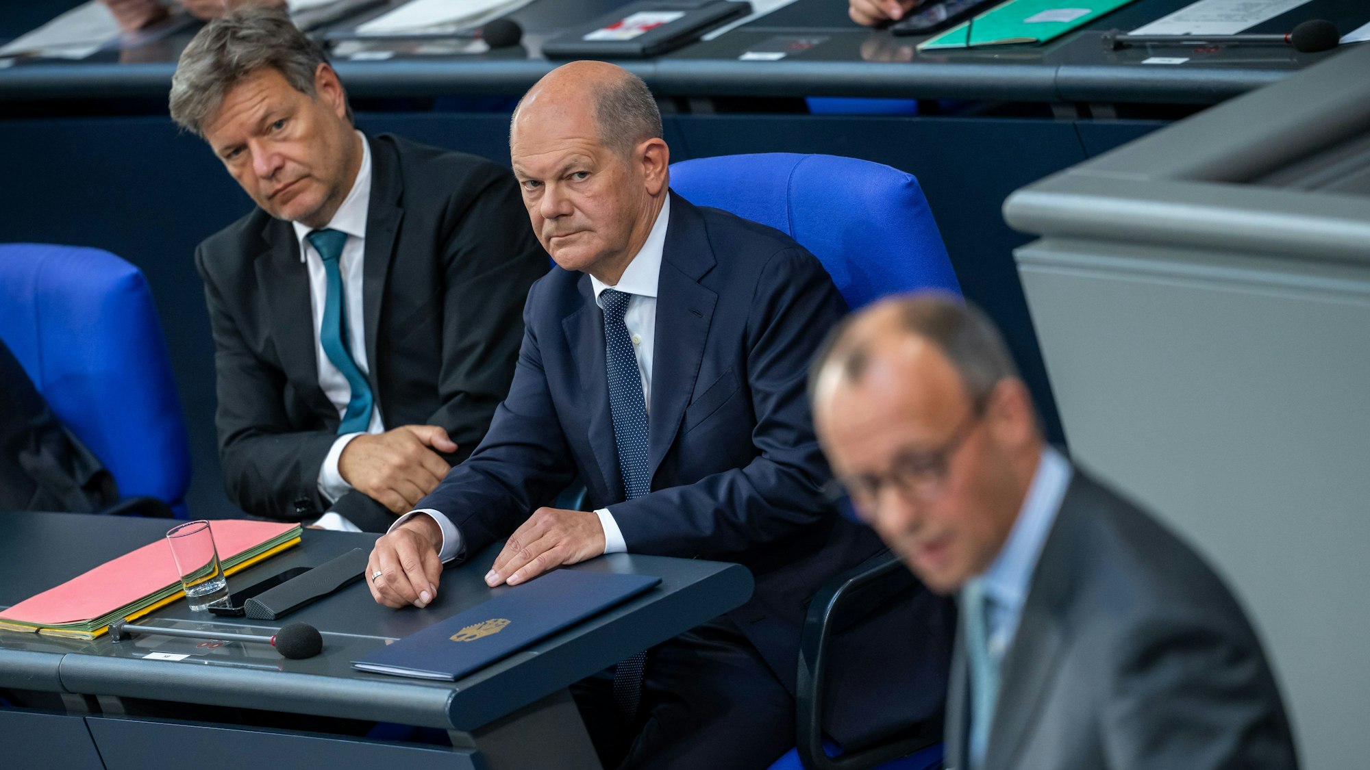 Friedrich Merz (vorn), CDU-Bundesvorsitzender und CDU/CSU Fraktionsvorsitzender im Bundestag, spricht vor Bundeskanzler Olaf Scholz (SPD, M) und Robert Habeck (Bündnis 90/Die Grünen), Bundesminister für Wirtschaft und Klimaschutz, nach der Regierungserklärung zu den Gipfeltreffen von EU und NATO im Bundestag.