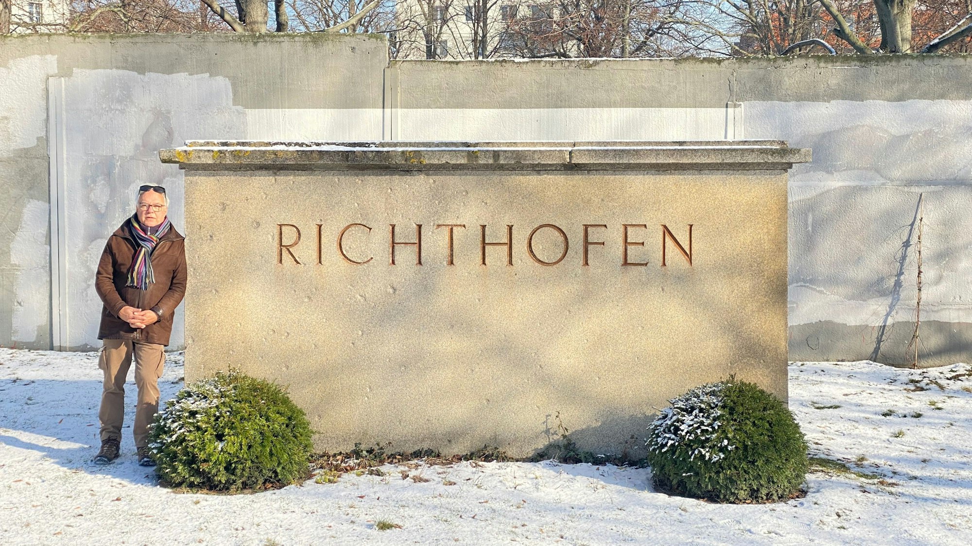 Das Foto zeigt Gerhard von Richthofen neben einem großen Grabstein.