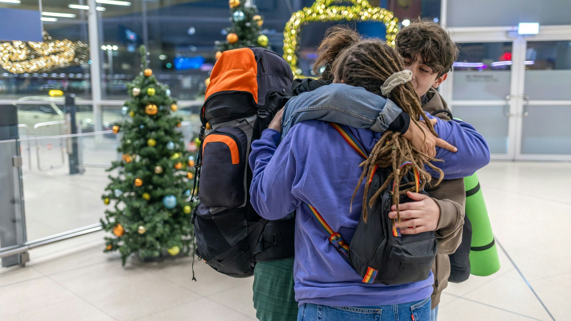 Drei Menschen umarmen sich.