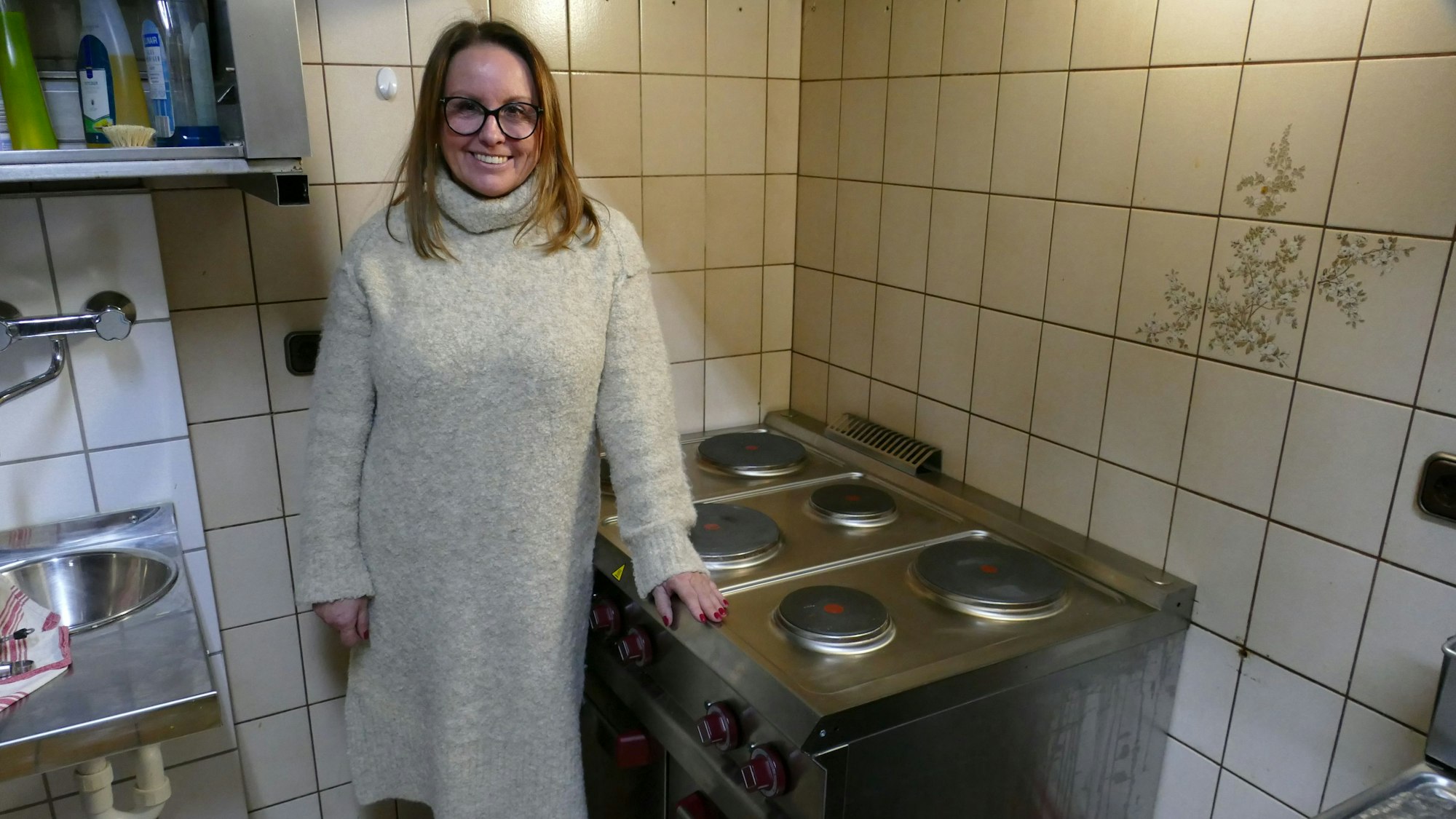 Eine Frau steht an einem großen Herd.