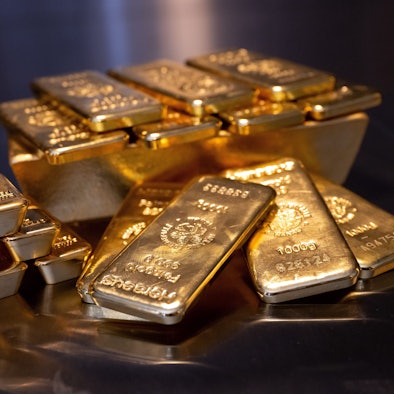 Goldbarren in unterschiedlicher Größe liegen bei einem Edelmetallhändler in einem Tresor auf einem Tisch.