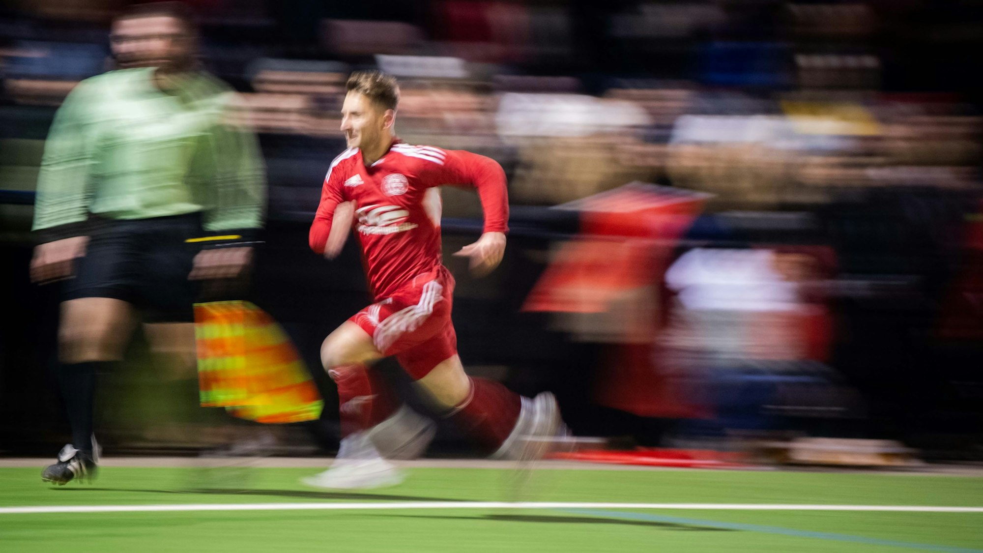 Devin Nickisch flitzt an der Seitenauslinie entlang. Der Fotograf hat die Kamera mitgezogen, sodass der Hintergrund stark verwischt.