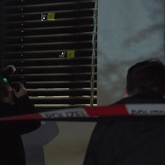 Polizeibeamte sichern Spuren nach einer Schussabgabe auf ein Wohnhaus in Köln-Westhoven.