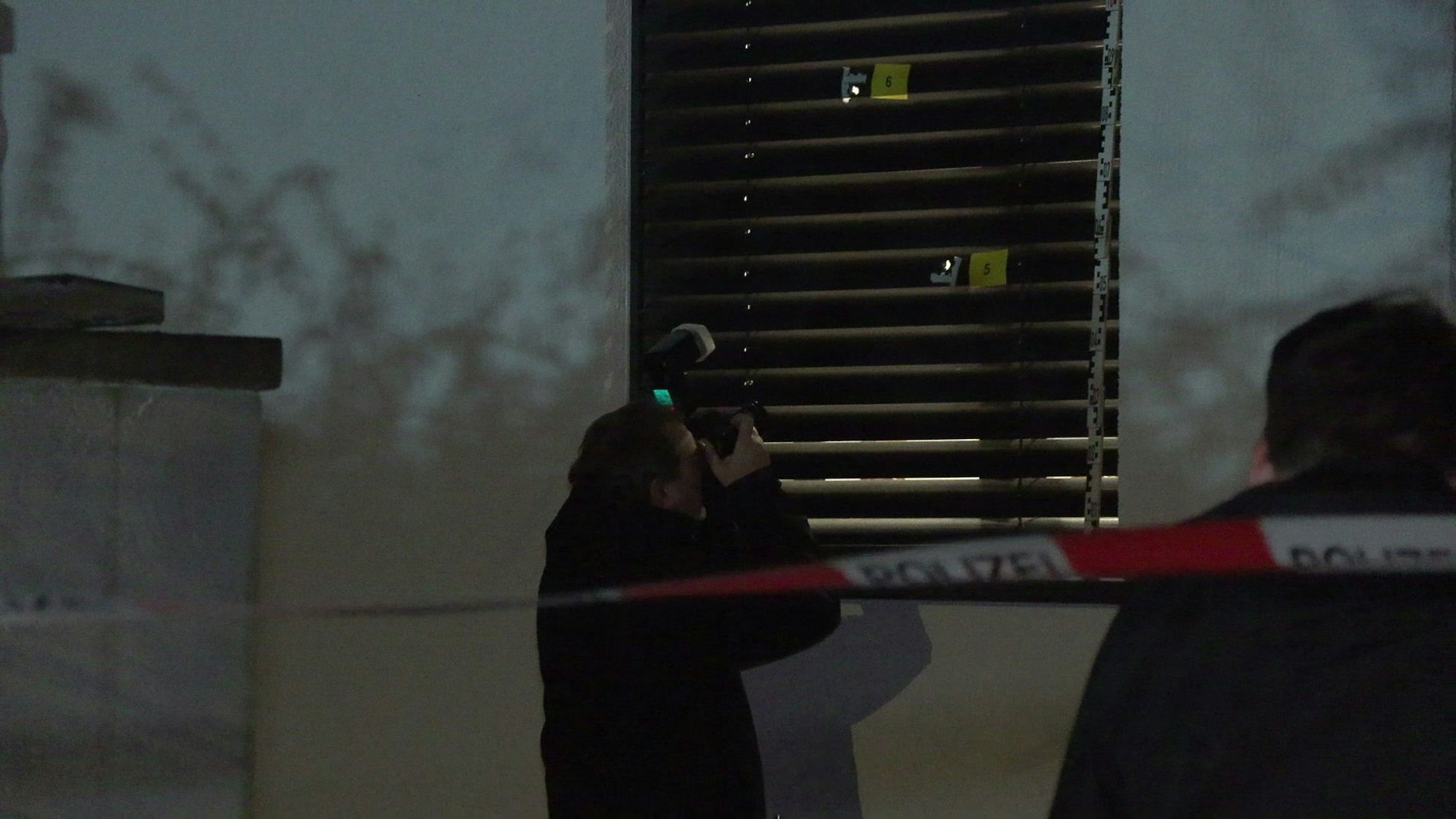 Polizeibeamte sichern Spuren nach einer Schussabgabe auf ein Wohnhaus in Köln-Westhoven.