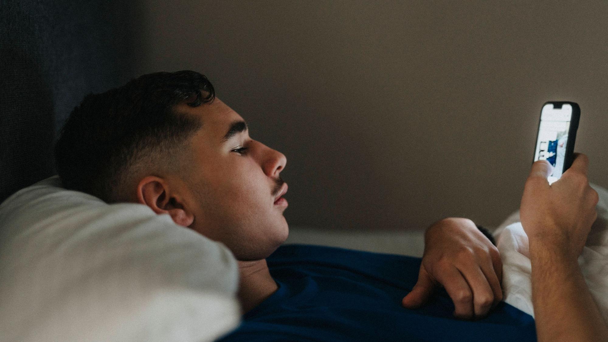 Teenage boy using mobile phone while lying in bedroom at home Sweden, Gothenburg, model released, property released Copyright: xMaskotx , MA106908 MA106908