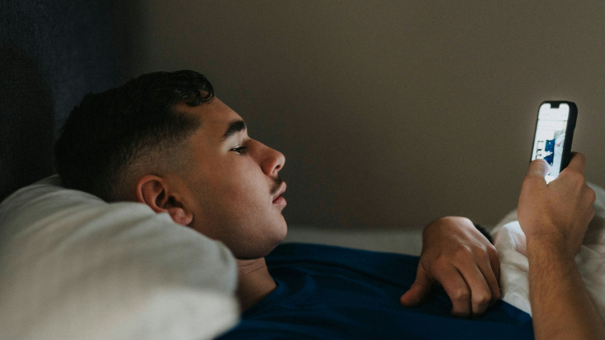 Teenage boy using mobile phone while lying in bedroom at home Sweden, Gothenburg, model released, property released Copyright: xMaskotx , MA106908 MA106908