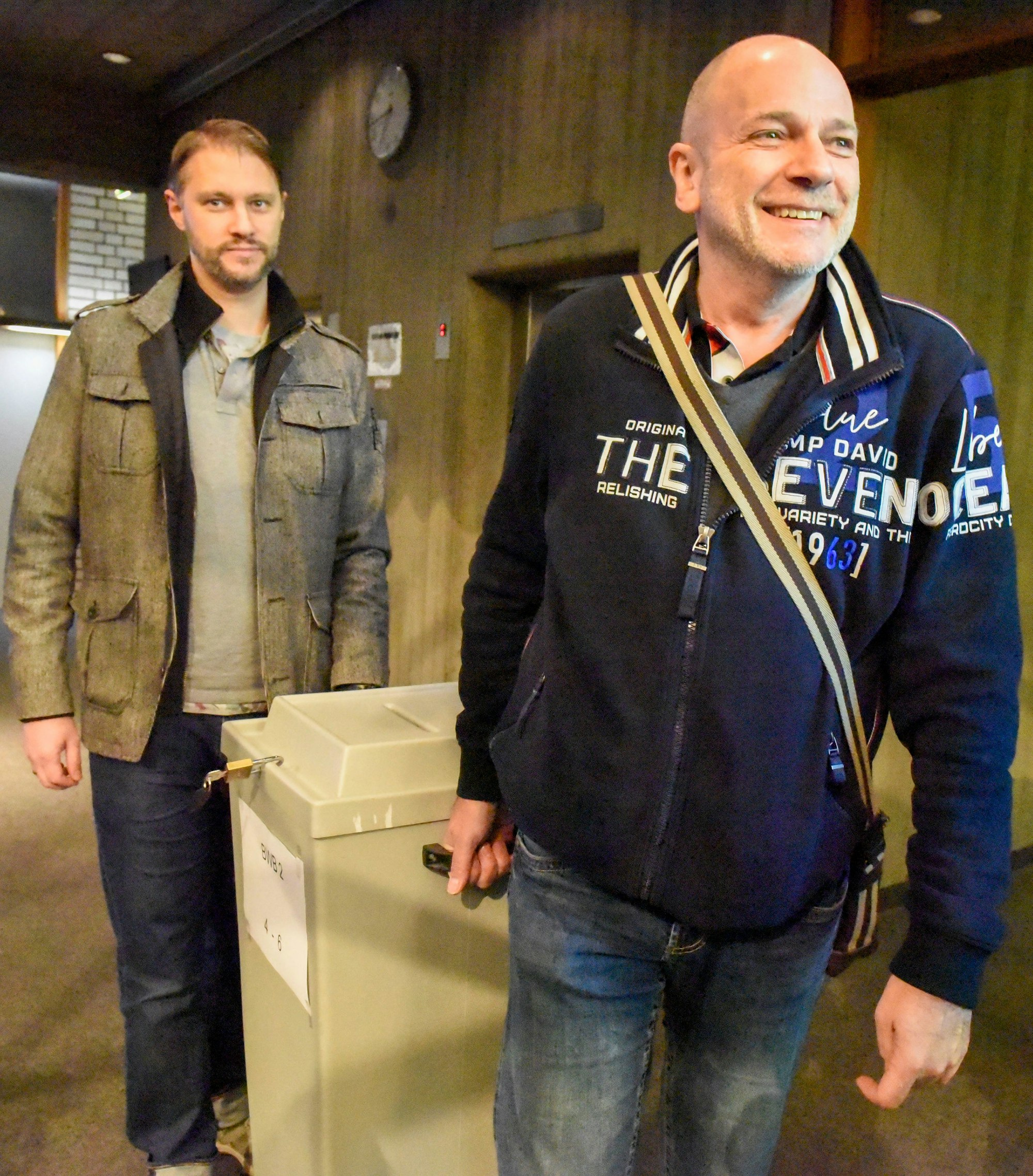 Wahlhelfer tragen eine ausgezählte Wahlurne; hier bei der Bürgermeister-Neuwahl 2022 in Wesseling.