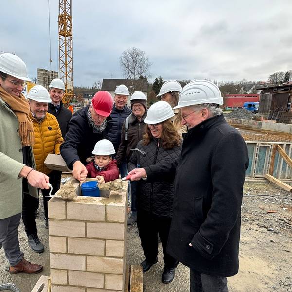 Ein Grundschüler hat Kinderwünsche für die Zukunft der Stadt Rösrath in der Zeitkapsel platziert, die anschließend eingemauert wird.