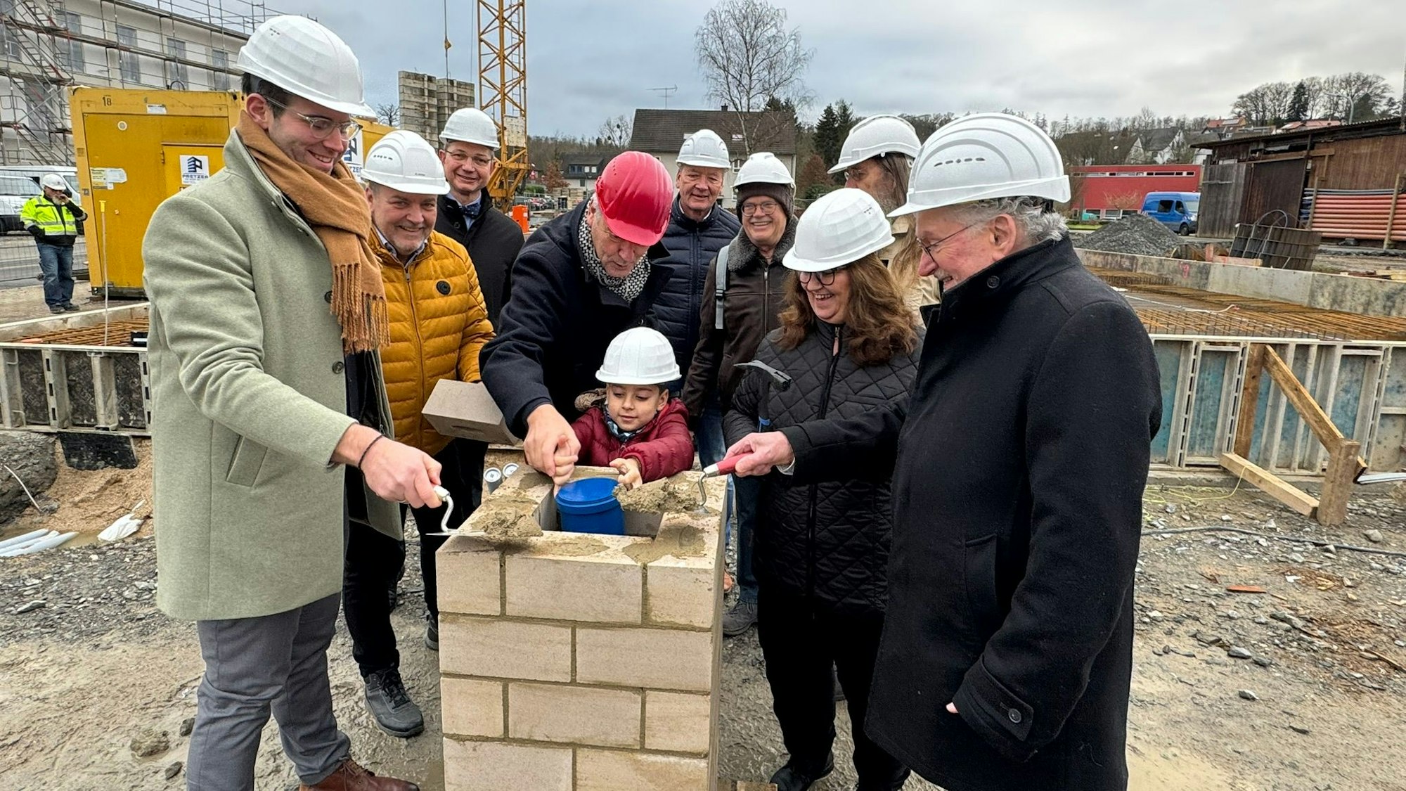 Ein Grundschüler hat Kinderwünsche für die Zukunft der Stadt Rösrath in der Zeitkapsel platziert, die anschließend eingemauert wird.