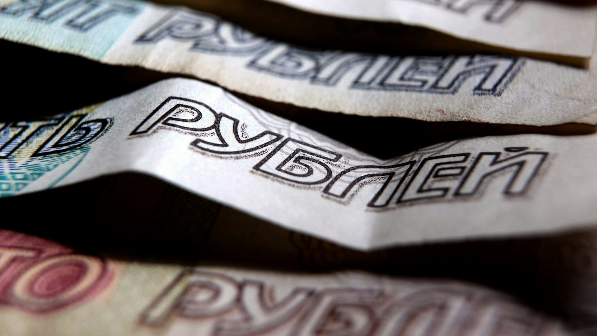 ARCHIV - 07.04.2022, Bayern, Kaufbeuren: Das russische Wort für Rubel ist auf verschiedenen Rubel-Banknoten zu lesen.