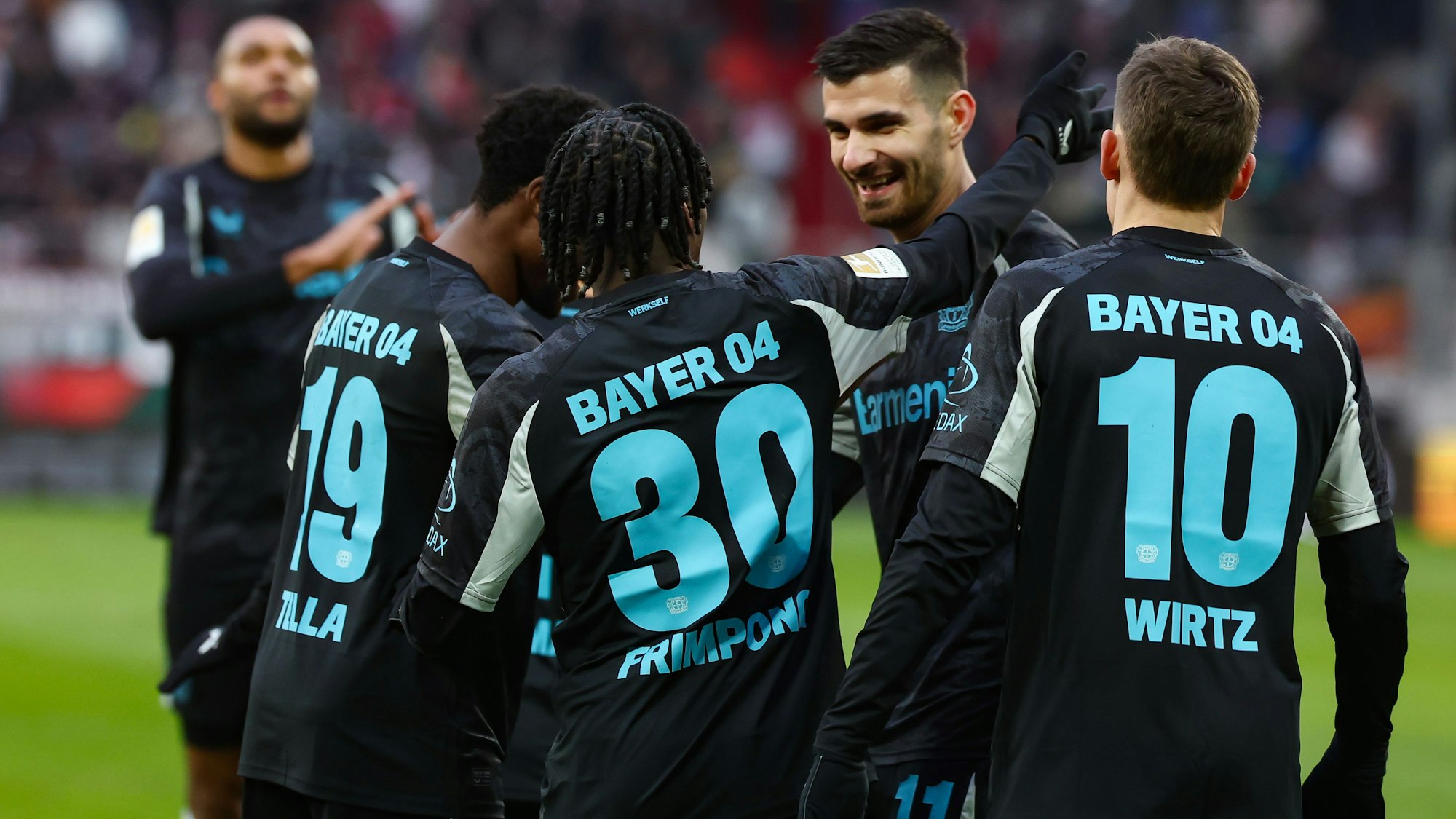 14.12.2024, Bayern, Augsburg: Fußball: Bundesliga, FC Augsburg - Bayer Leverkusen, 14. Spieltag, WWK-Arena. Martin Terrier von Bayer Leverkusen (2.v.r) lässt sich nach seinem Treffer zum 0:1 bejubeln. Foto: Daniel Löb/dpa - WICHTIGER HINWEIS: Gemäß den Vorgaben der DFL Deutsche Fußball Liga bzw. des DFB Deutscher Fußball-Bund ist es untersagt, in dem Stadion und/oder vom Spiel angefertigte Fotoaufnahmen in Form von Sequenzbildern und/oder videoähnlichen Fotostrecken zu verwerten bzw. verwerten zu lassen. +++ dpa-Bildfunk +++