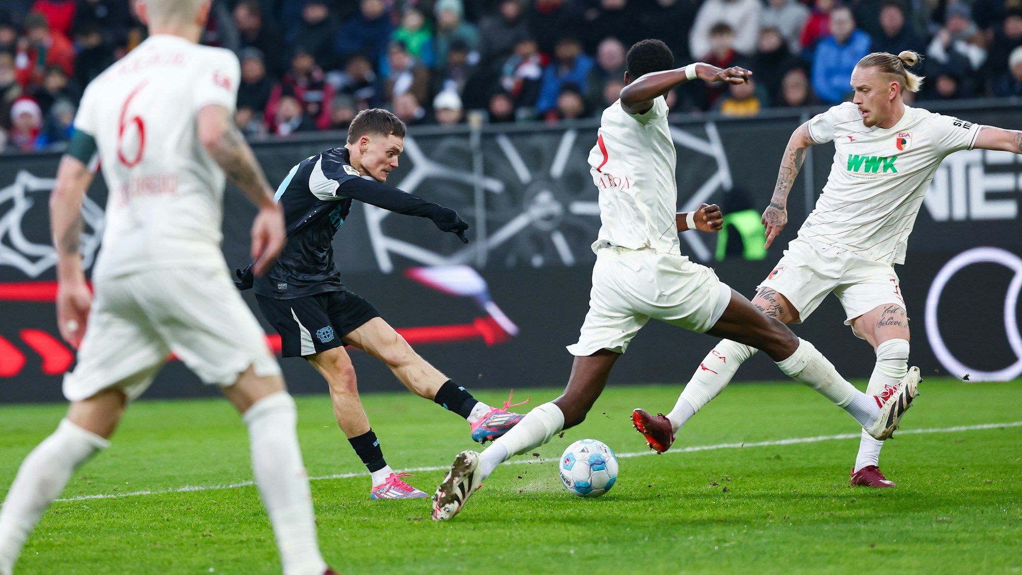 14.12.2024, Bayern, Augsburg: Fußball: Bundesliga, FC Augsburg - Bayer Leverkusen, 14. Spieltag, WWK-Arena. Florian Wirtz von Bayer Leverkusen (M) trifft zum 0:2. Foto: Daniel Löb/dpa - WICHTIGER HINWEIS: Gemäß den Vorgaben der DFL Deutsche Fußball Liga bzw. des DFB Deutscher Fußball-Bund ist es untersagt, in dem Stadion und/oder vom Spiel angefertigte Fotoaufnahmen in Form von Sequenzbildern und/oder videoähnlichen Fotostrecken zu verwerten bzw. verwerten zu lassen. +++ dpa-Bildfunk +++