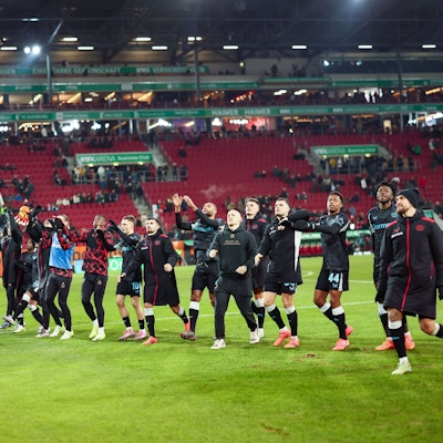 14.12.2024, Bayern, Augsburg: Fußball: Bundesliga, FC Augsburg - Bayer Leverkusen, 14. Spieltag, WWK-Arena. Das Team von Bayer 04 Leverkusen jubelt nach dem Spiel mit den Fans. Foto: Daniel Löb/dpa - WICHTIGER HINWEIS: Gemäß den Vorgaben der DFL Deutsche Fußball Liga bzw. des DFB Deutscher Fußball-Bund ist es untersagt, in dem Stadion und/oder vom Spiel angefertigte Fotoaufnahmen in Form von Sequenzbildern und/oder videoähnlichen Fotostrecken zu verwerten bzw. verwerten zu lassen. +++ dpa-Bildfunk +++