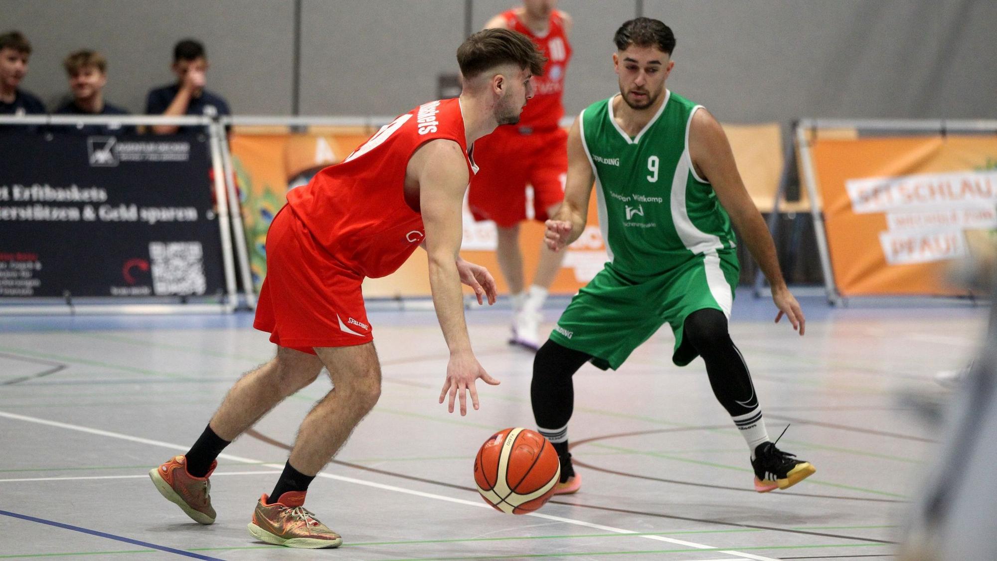 Ein Basketballer dribbelt auf einen Gegner zu. Der Ball befindet sich fast auf dem Boden.