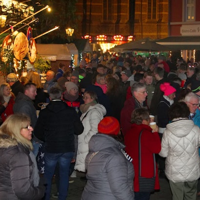 Auf dem Bild sind viele Besucher des Weihnachtsmarktes zu sehen.