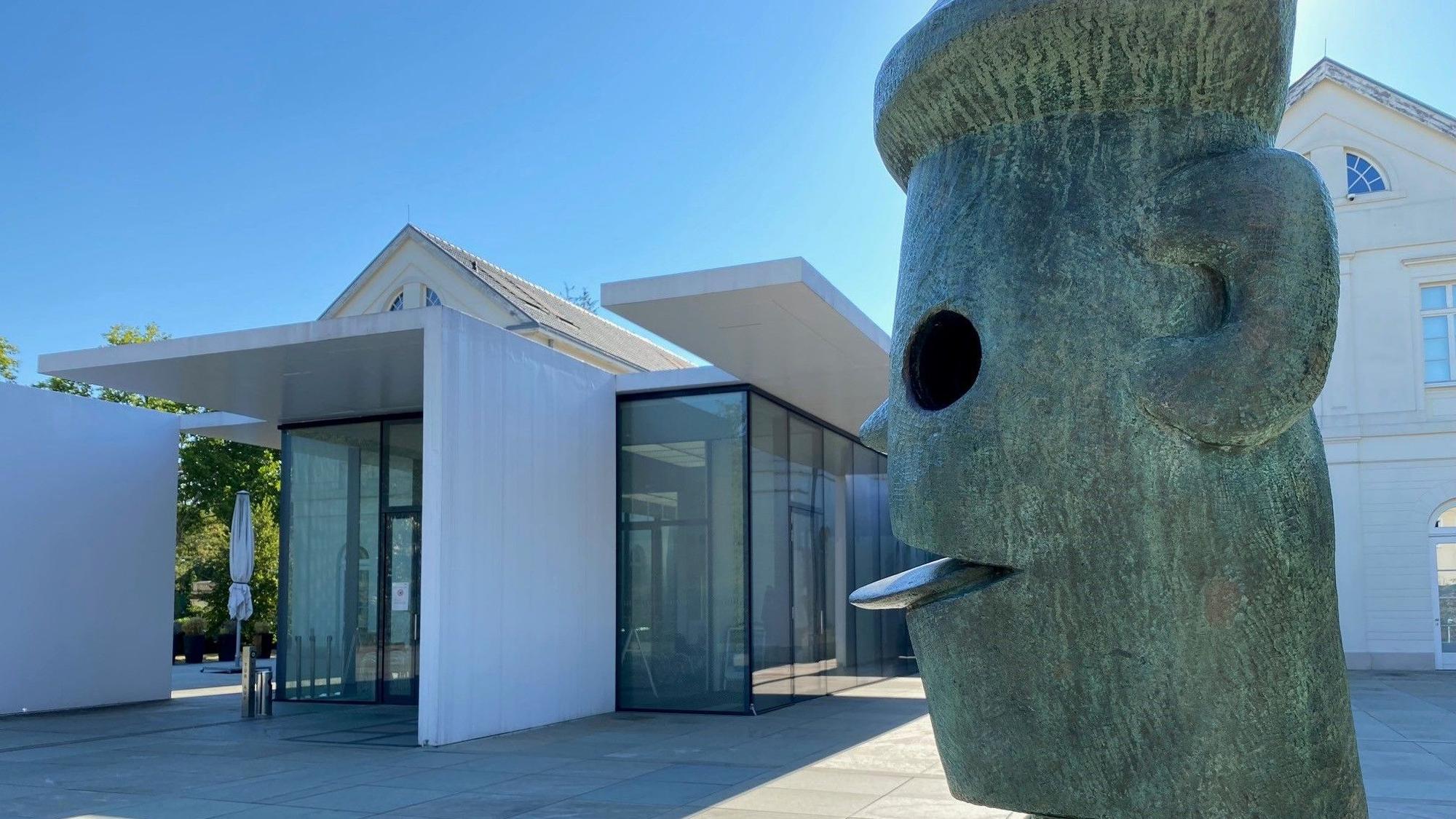 Auf dem Bild ist das Gebäude des Max Ernst Museums und eine Skulptur von Max Ernst zu sehen.