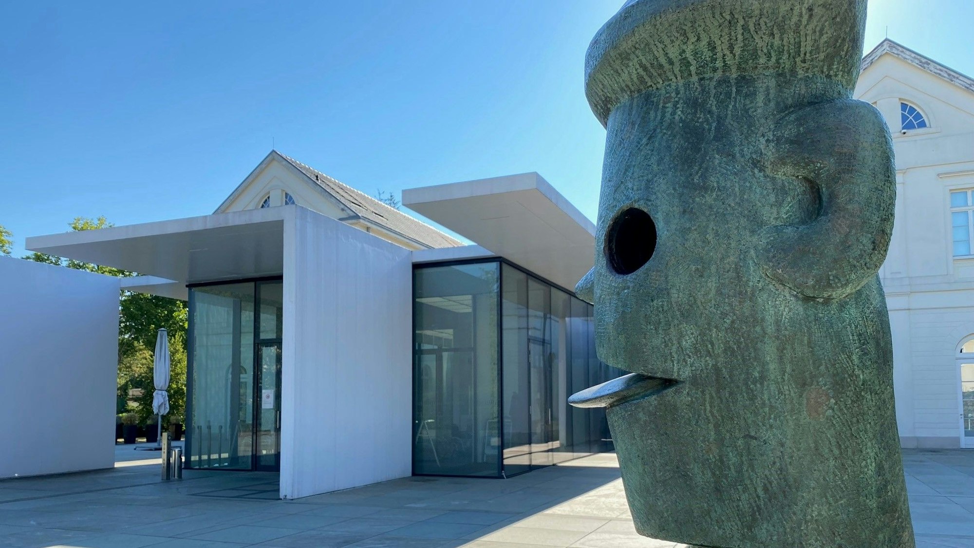 Auf dem Bild ist das Gebäude des Max Ernst Museums und eine Skulptur von Max Ernst zu sehen.