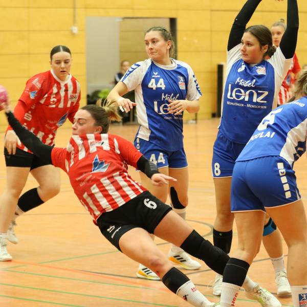 Eine Handballerin liegt beim Wurf schräg in der Luft. Sie wurde allerdings unsanft gestoppt.