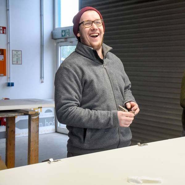 Auf dem Bild sind zwei Handwerker in der Werkstatt zu sehen.