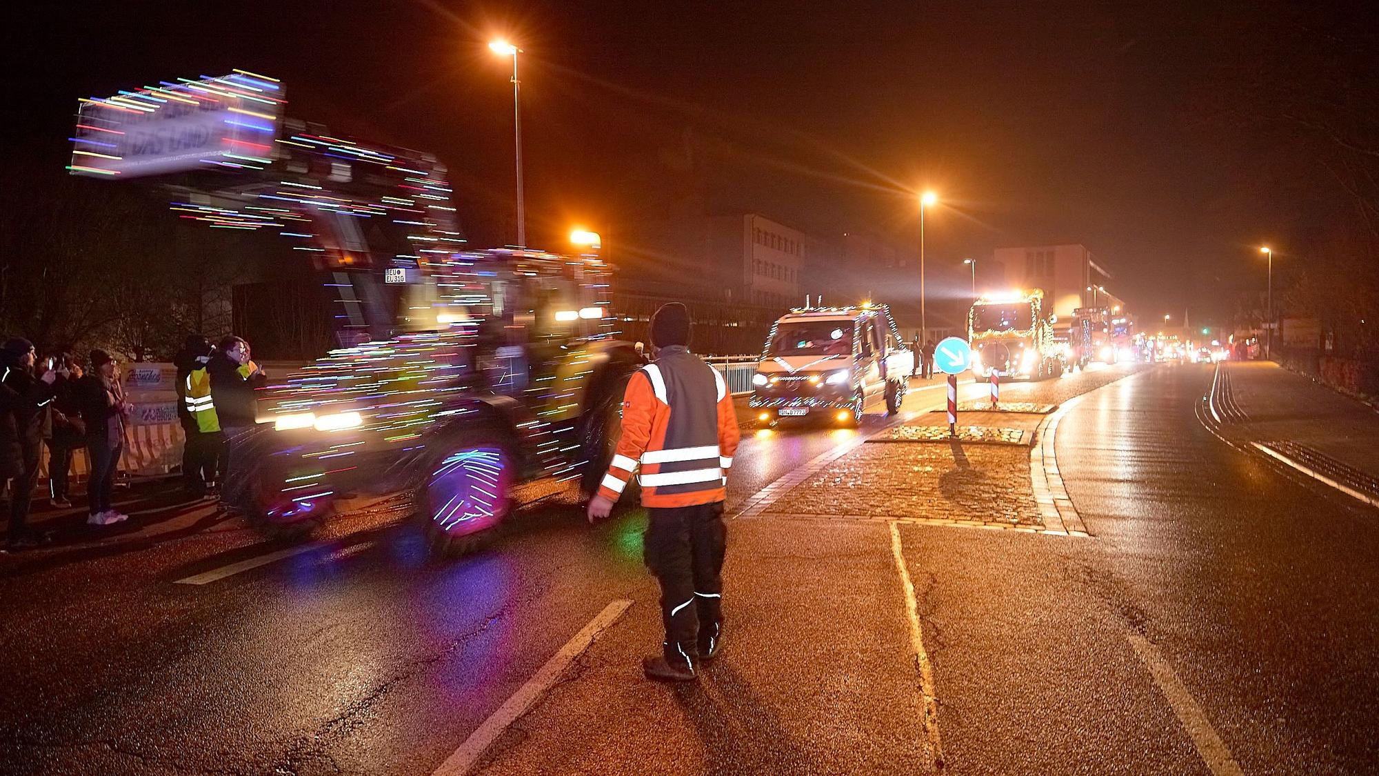 Vorne ist Christian Stoll von hinten zu sehen. Die Fahrzeuge fahren an ihm vorbei.